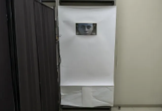 白い仕切りの中央にディスプレイが設置されたブース